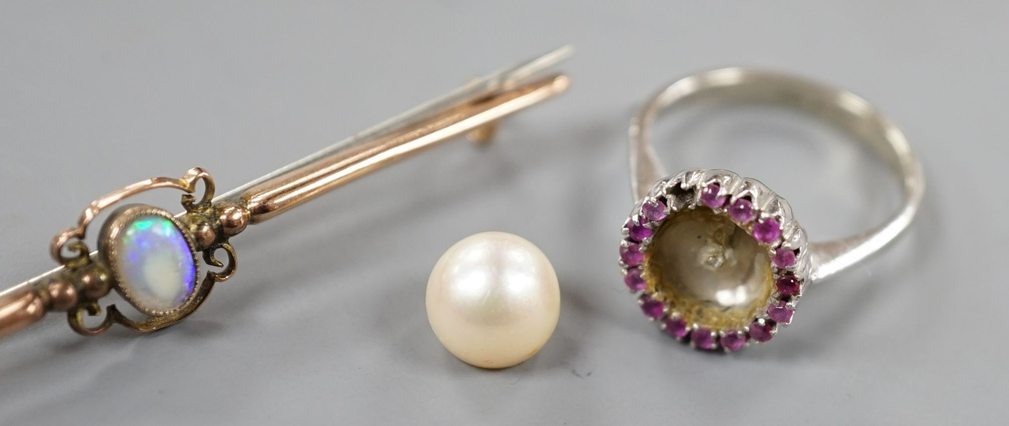 A modern Italian 18ct white gold, cultured pearl and ruby cluster set dress ring (pearl loose and missing one ruby), size N, gross 3.9 grams and a 9ct and white opal set bar brooch, gross 2.2 grams.